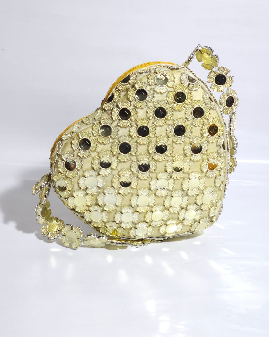 Decorative handbag with black and gold polka dot pattern on a white background