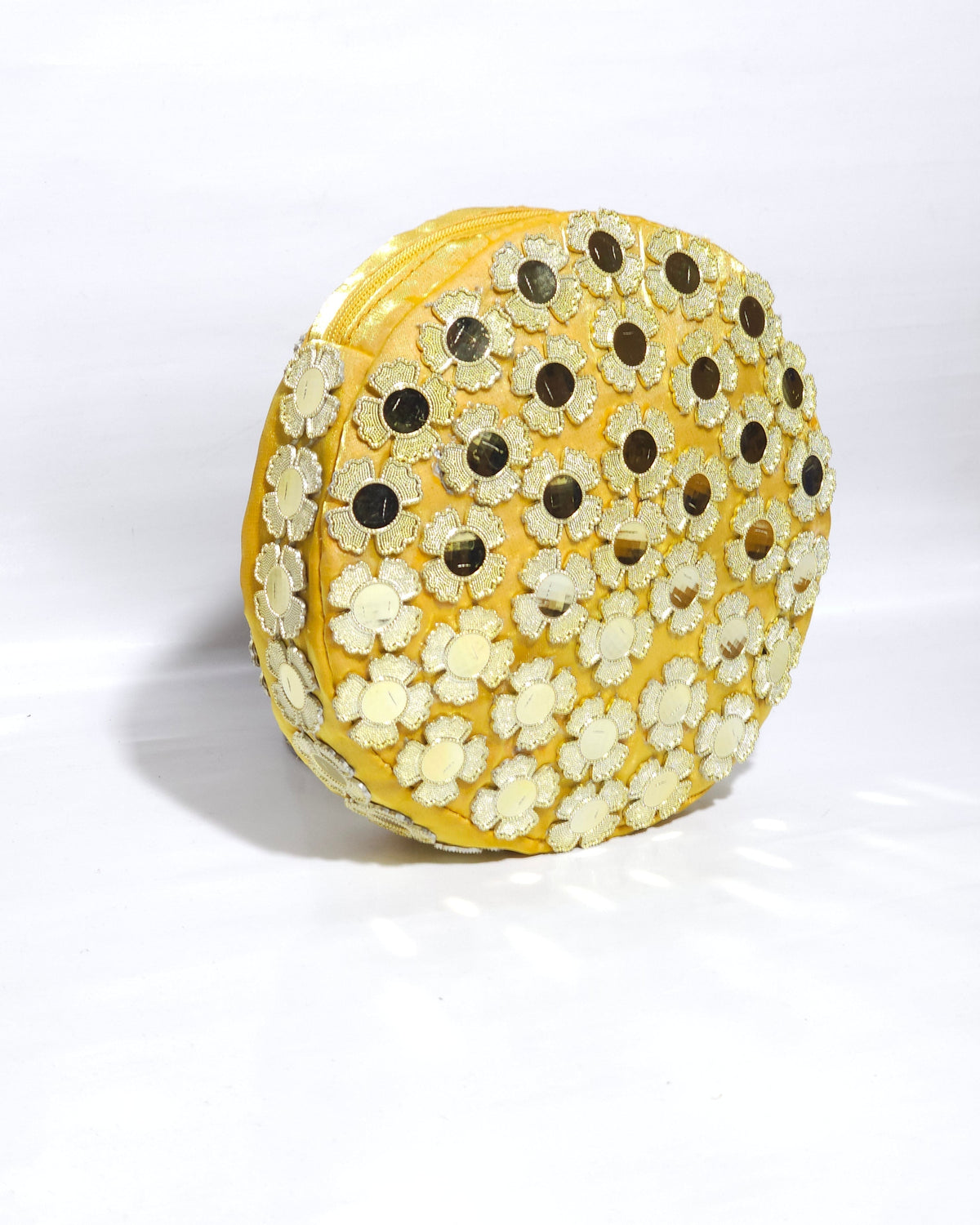 Round GOLDEN  yellow CLUTCH BAG with floral patterns on a white background