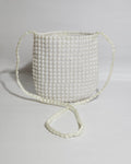 Pearl-handled bag on a light gray background