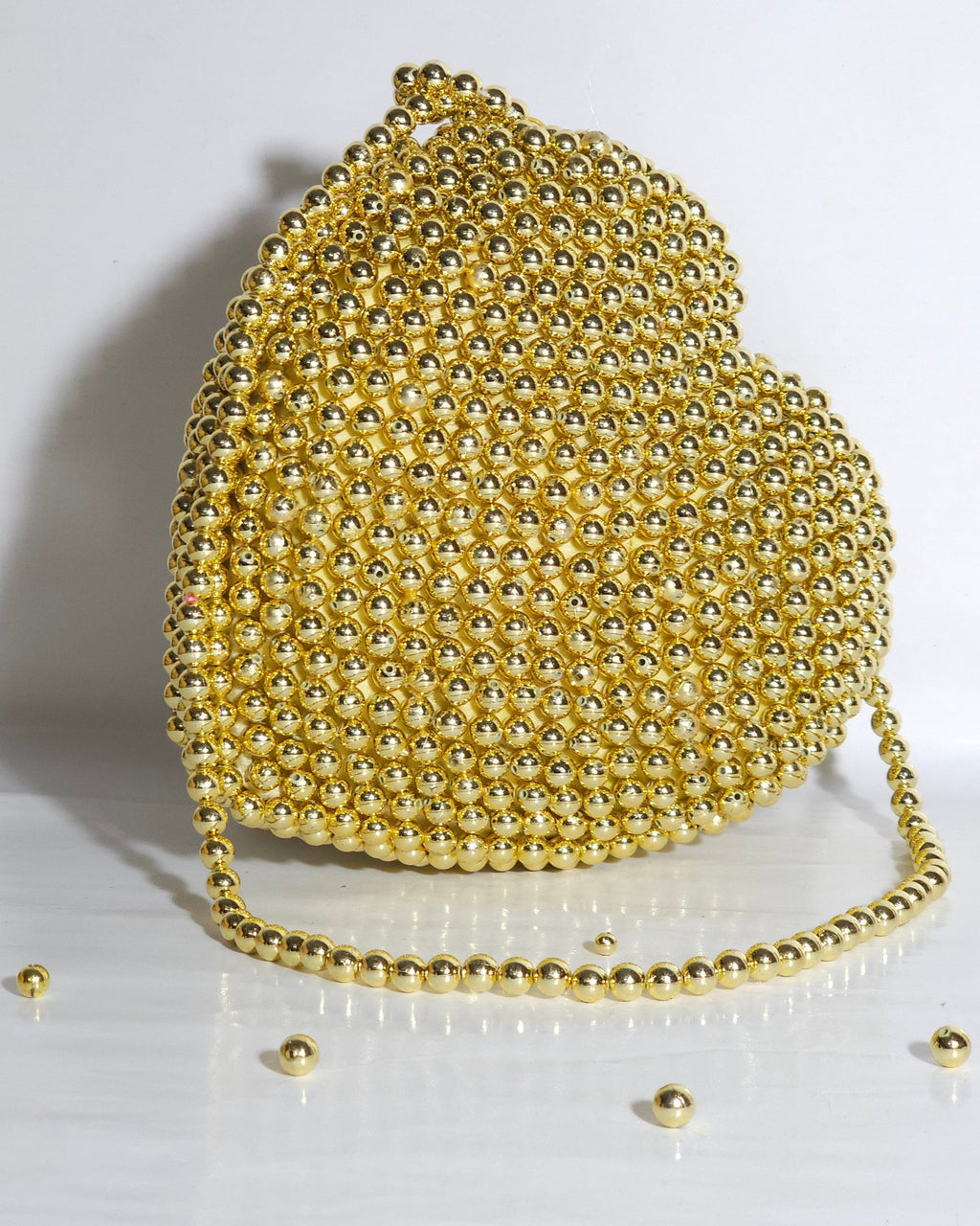 Gold beaded handbag on a white background