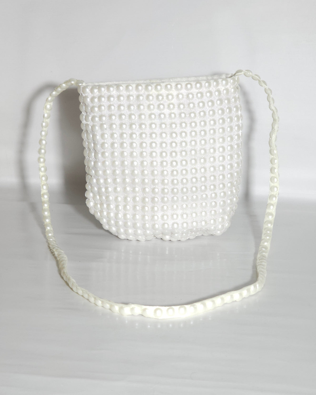 White pearl-handled bag on a light gray background