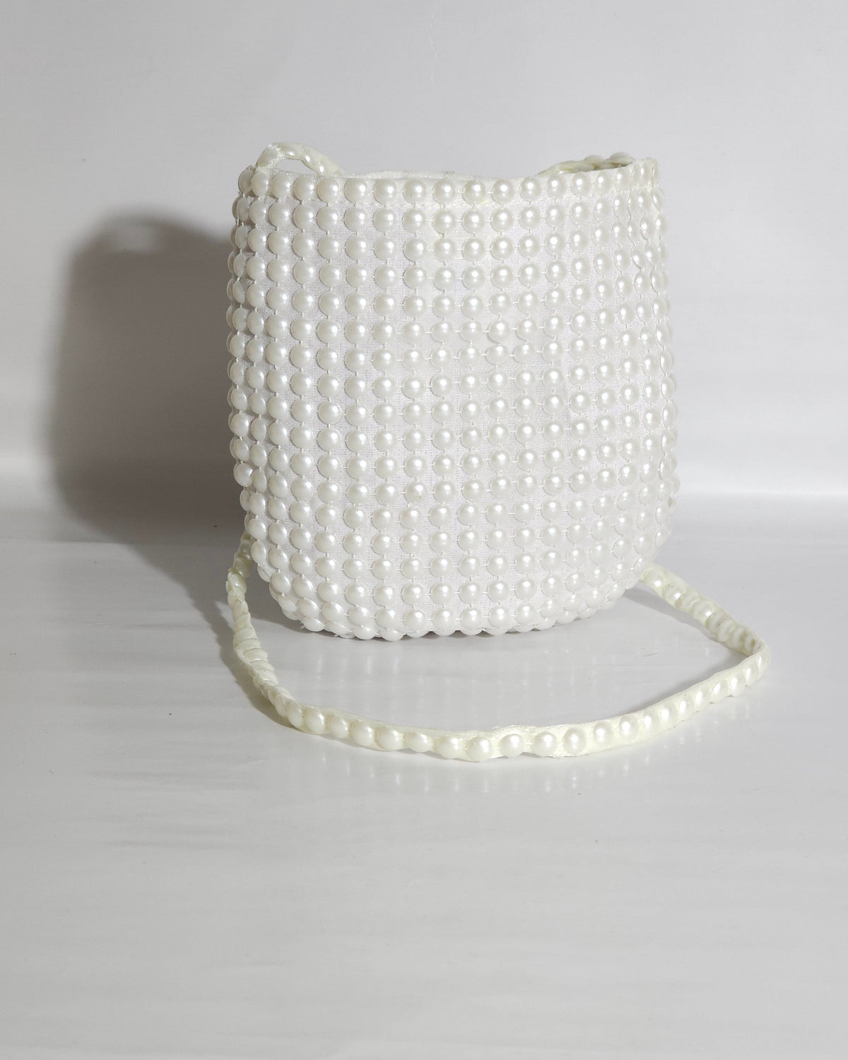 White beaded handbag on a light gray background